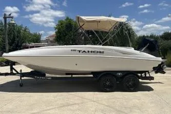 Slide: The Image of 2026 Tahoe 2150 boat on trailer, parked outdoors under a clear blue sky. - 2