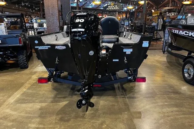 Slide: The Image of 2026 Tracker Pro Guide V-16 WT boat with 90 HP engine displayed indoors. - 3