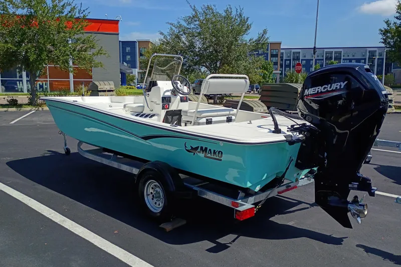 Slide: The Image of 2026 Mako Pro Skiff 17 CC boat with Mercury engine in parking lot. - 2