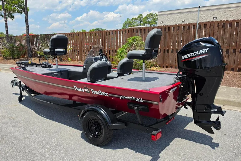 Slide: The Image of 2026 Tracker Bass Tracker Classic XL boat with Mercury engine, parked outdoors. - 9
