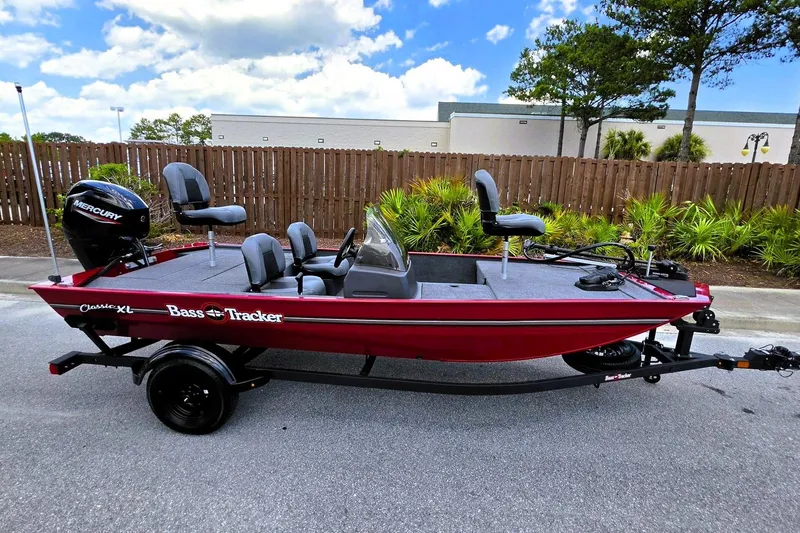 Slide: The Image of 2026 Tracker Bass Tracker Classic XL boat with Mercury engine, parked outdoors. - 6