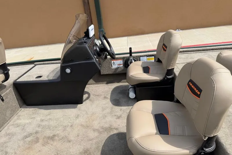 Slide: The Image of 2026 Tracker Bass Tracker Classic Limited boat interior with beige seats and steering console. - 8