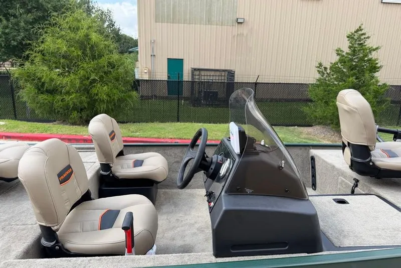 Slide: The Image of 2026 Tracker Bass Tracker Classic Limited boat interior with beige seats and steering console. - 4