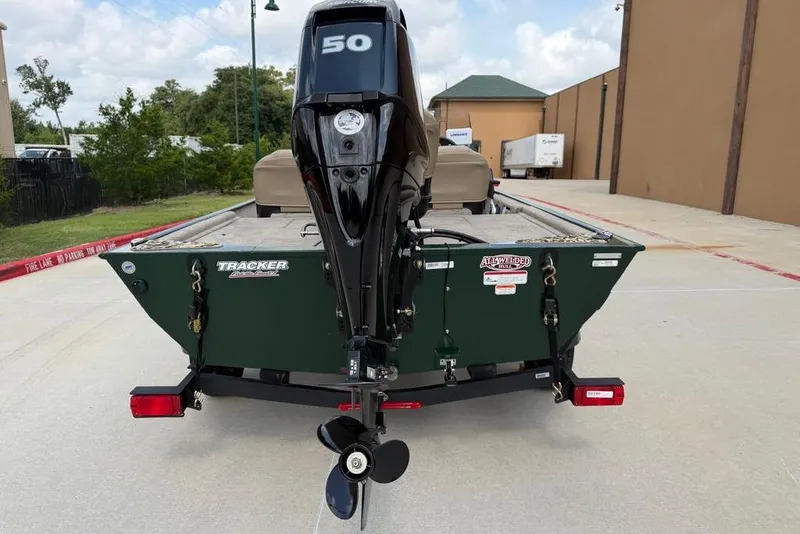 Slide: The Image of 2026 Tracker Bass Tracker Classic Limited boat with 50 HP motor, parked outdoors. - 15