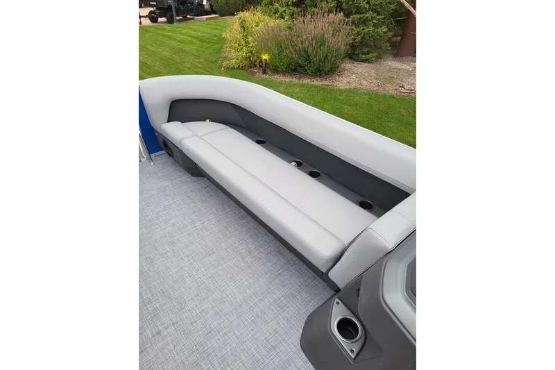Slide: The Image of 2026 Sun Tracker Party Barge 18 DLX interior with gray seating and cup holders. - 5
