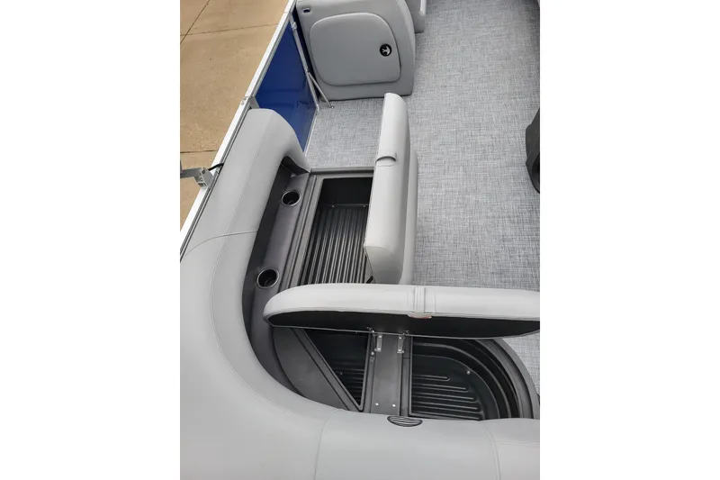 Slide: The Image of 2026 Sun Tracker Party Barge 18 DLX interior with open storage compartment and cup holders. - 8