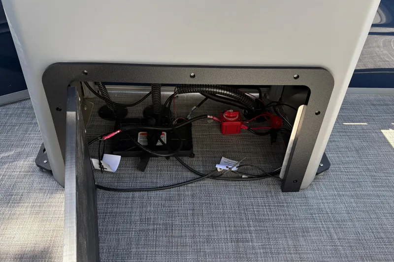 Slide: The Image of Under-seat storage compartment of 2026 Sun Tracker Sportfish 24 XP3 boat, showing wiring and components. - 18