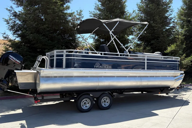 Slide: The Image of 2026 Sun Tracker Sportfish 24 XP3 pontoon boat on trailer, parked outdoors. - 3
