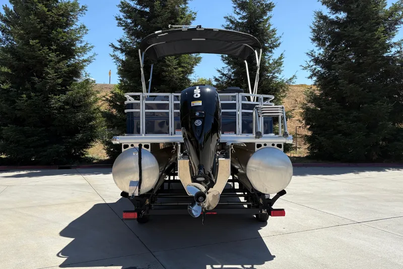 Slide: The Image of 2026 Sun Tracker Sportfish 24 XP3 pontoon boat with powerful outboard motor, parked outdoors. - 4