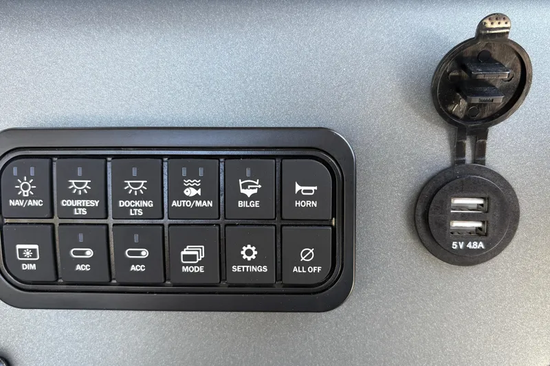 Slide: The Image of Control panel of 2026 Sun Tracker Sportfish 24 XP3 with USB ports and various switches. - 22