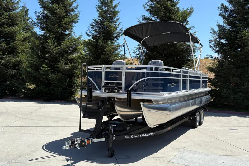 Slide: The Image of 2026 Sun Tracker Sportfish 24 XP3 pontoon boat on trailer, parked outdoors. - 8