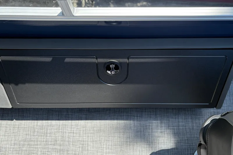 Slide: The Image of 2026 Sun Tracker Sportfish 24 XP3 storage compartment with sleek black finish and secure latch. - 27