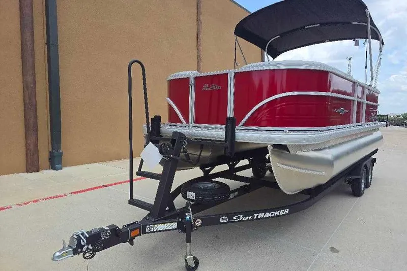 Slide: The Image of 2026 Sun Tracker Party Barge 20 DLX pontoon boat on trailer, red exterior, black canopy. - 2