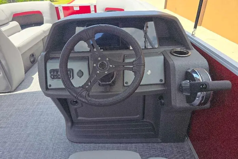 Slide: The Image of 2026 Sun Tracker Party Barge 20 DLX steering console with seating in background. - 15