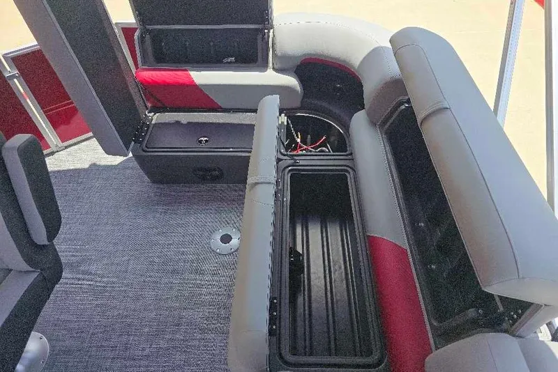Slide: The Image of 2026 Sun Tracker Party Barge 20 DLX interior with open storage compartments and seating. - 13