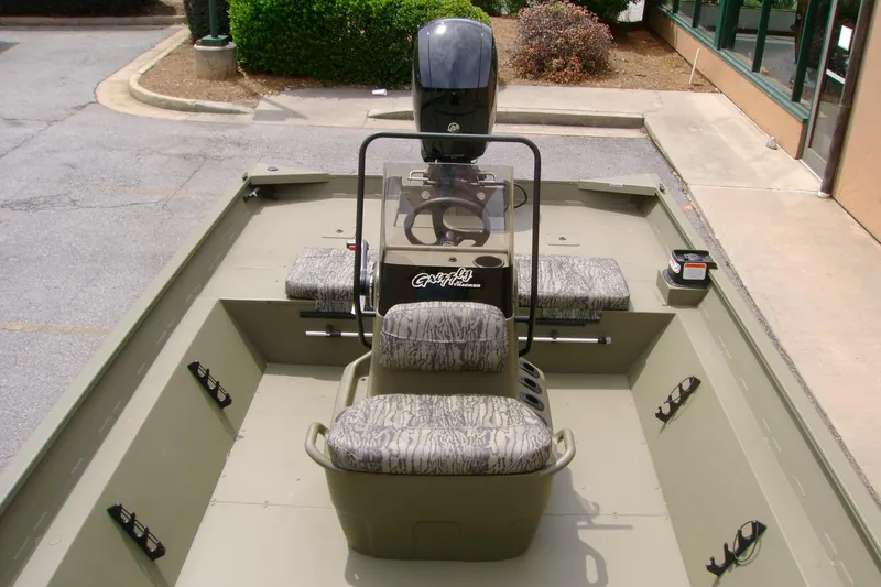 Slide: The Image of 2026 Tracker Grizzly 2072 CC boat interior with camouflage seating and steering console. - 5