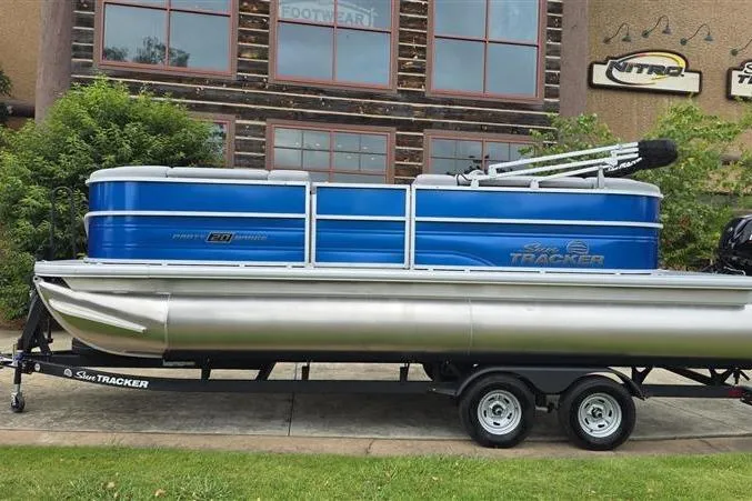 Slide: The Image of 2026 Sun Tracker Party Barge 20 DLX pontoon boat on trailer, parked outdoors. - 4