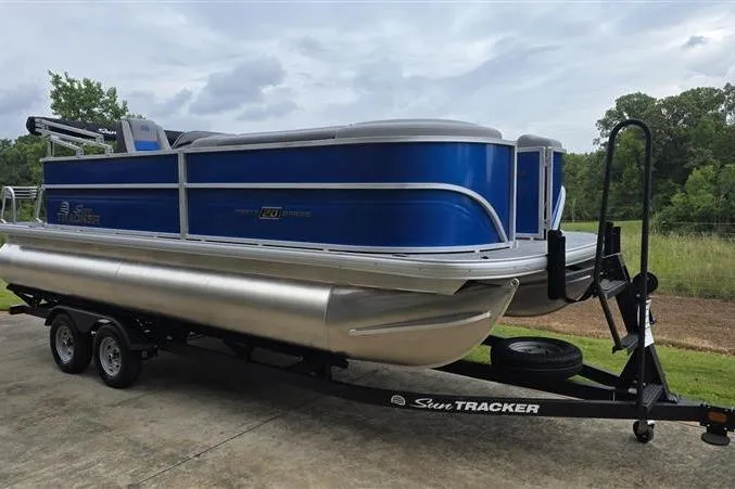 Slide: The Image of 2026 Sun Tracker Party Barge 20 DLX pontoon boat on trailer, parked outdoors. - 7