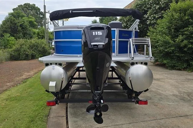 Slide: The Image of 2026 Sun Tracker Party Barge 20 DLX pontoon boat with Mercury 115 engine, parked outdoors. - 2