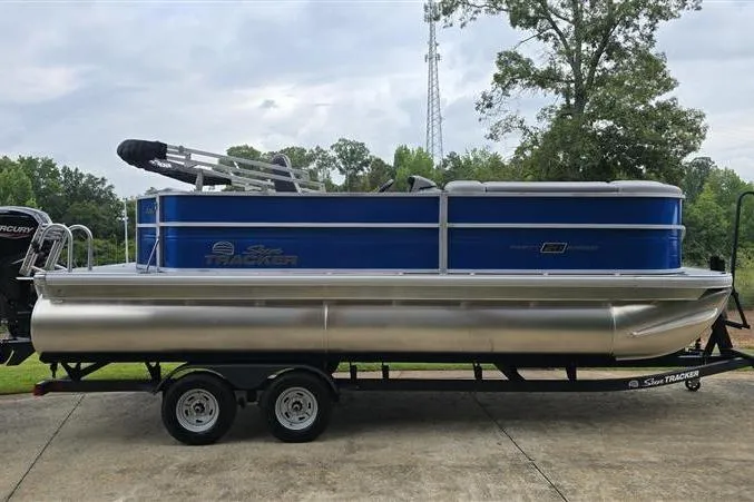 The Image of 2026 Sun Tracker Party Barge 20 DLX pontoon boat on trailer, parked outdoors. - 0
