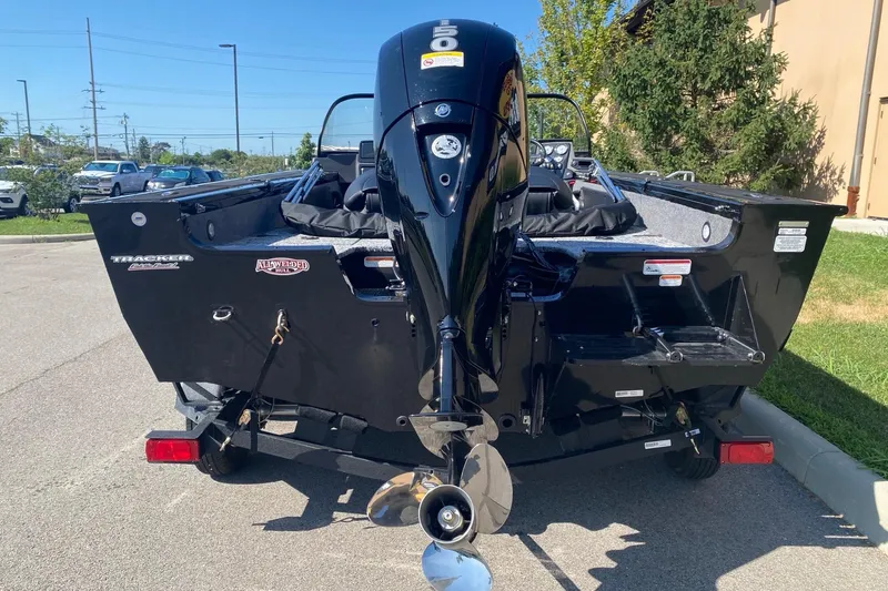 Slide: The Image of 2026 Tracker Targa V-19 Combo boat with powerful outboard motor in a parking lot. - 5
