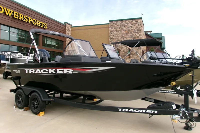 The Image of 2026 Tracker Pro Guide V-16 SC boat displayed outside a powersports store. - 0