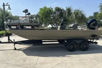 Slide: The Image of 2026 Tracker Grizzly 2072 CC Sportsman boat on trailer, parked outdoors. - 2