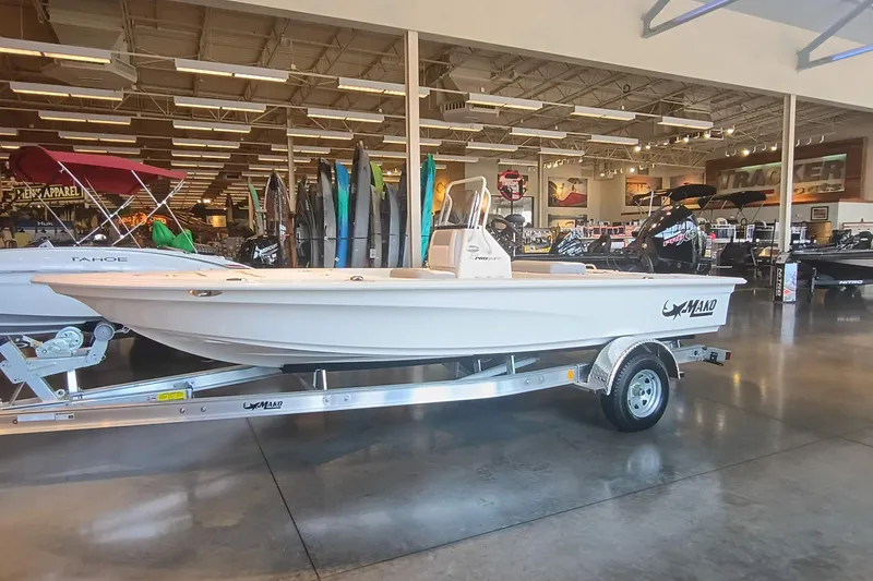 Slide: The Image of 2026 Mako 18 Pro Skiff boat displayed in a showroom on a trailer. - 1