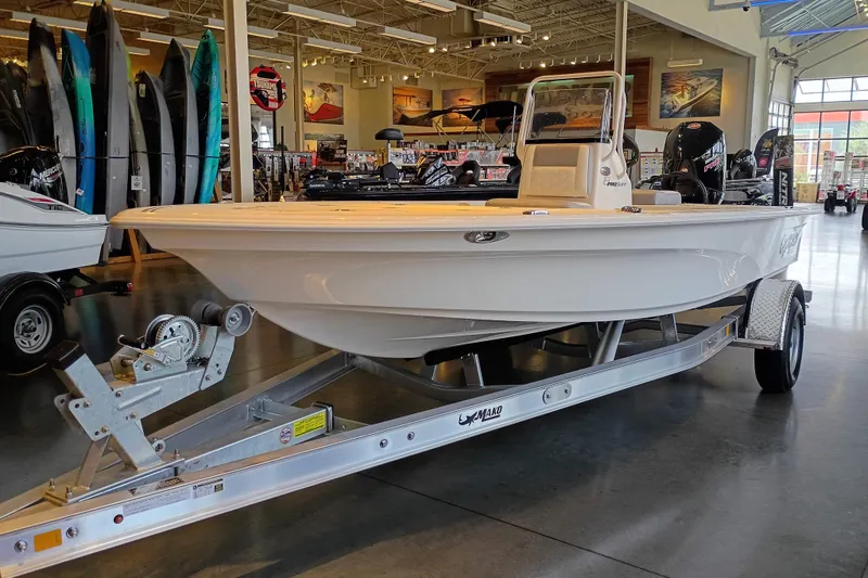 The Image of 2026 Mako 18 Pro Skiff boat displayed indoors on a trailer. - 0