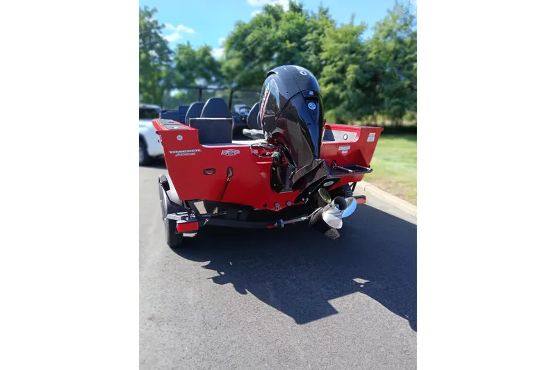Slide: The Image of 2026 Tracker Targa V-18 WT boat, red exterior, parked on a sunny day. - 5