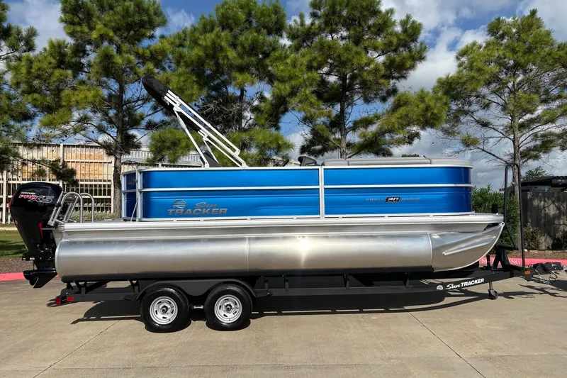 Slide: The Image of 2026 Sun Tracker Party Barge 20 DLX pontoon boat on trailer, parked outdoors. - 3