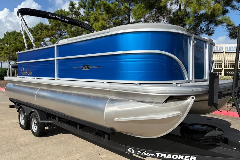 Slide: The Image of 2026 Sun Tracker Party Barge 20 DLX pontoon boat on trailer, blue exterior. - 2