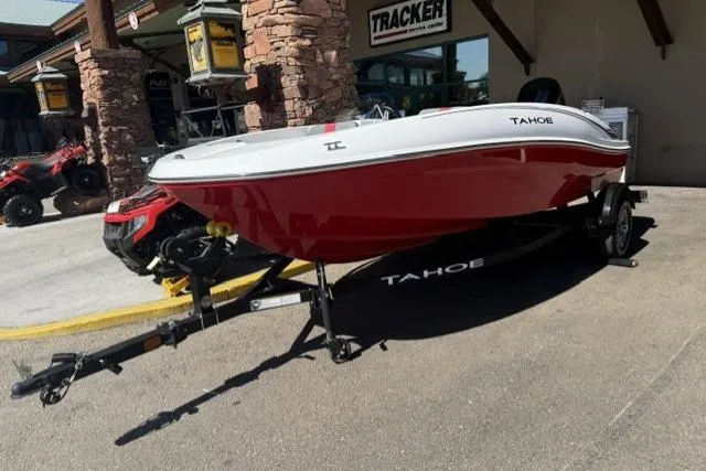 The Image of 2026 Tahoe T16 boat in red and white on a trailer outside a store. - 0