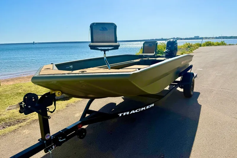 Slide: The Image of 2026 Tracker Grizzly 1756 T Marsh boat on trailer by a scenic lakeside. - 20