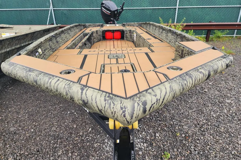 Slide: The Image of 2026 Tracker Grizzly 1756 T Marsh boat with camouflage design on gravel surface. - 3