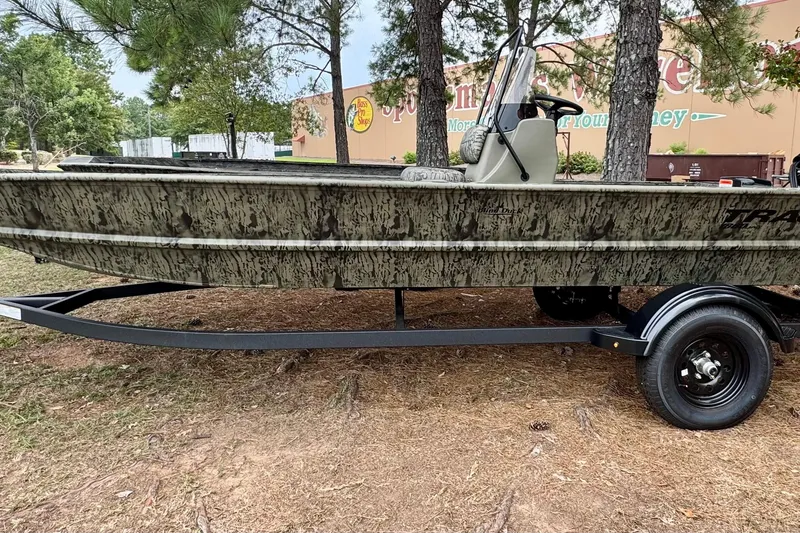 The Image of 2026 Tracker Grizzly 1860 CC boat on trailer, parked outdoors near trees. - 0