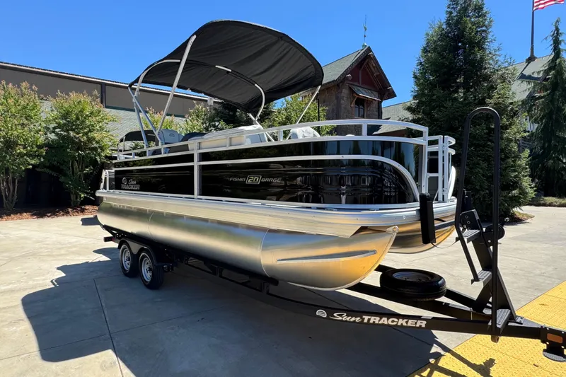 Slide: The Image of 2026 Sun Tracker Fishin' Barge 20 DLX pontoon boat on trailer, parked outdoors. - 6