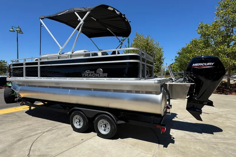 Slide: The Image of 2026 Sun Tracker Fishin' Barge 20 DLX pontoon boat with Mercury engine on trailer. - 1
