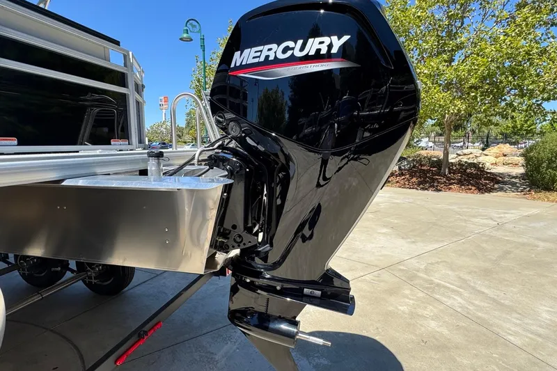 Slide: The Image of 2026 Sun Tracker Fishin' Barge 20 DLX with Mercury outboard motor in a sunny outdoor setting. - 4