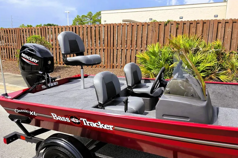 Slide: The Image of 2026 Tracker Bass Tracker Classic XL boat with Mercury engine, parked outdoors. - 12