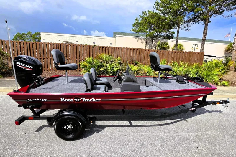 Slide: The Image of 2026 Tracker Bass Tracker Classic XL boat with Mercury engine, parked outdoors. - 6