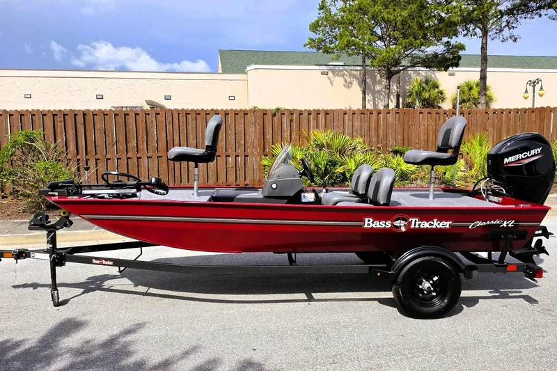 Slide: The Image of 2026 Tracker Bass Tracker Classic XL boat with Mercury engine, parked outdoors. - 7