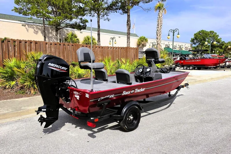 Slide: The Image of 2026 Tracker Bass Tracker Classic XL boat with Mercury engine, parked outdoors. - 2