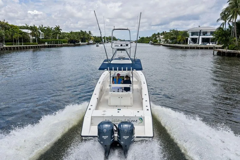 Slide: The Image of 1997 Venture 34 Center Console boat cruising on a scenic waterway with palm trees. - 11