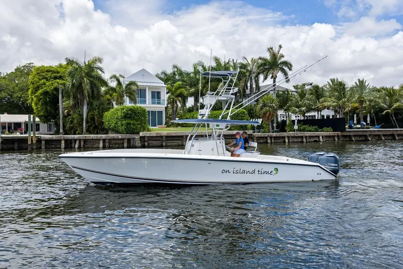 Slide: The Image of 1997 Venture 34 Center Console boat cruising near palm-lined waterfront homes. - 12