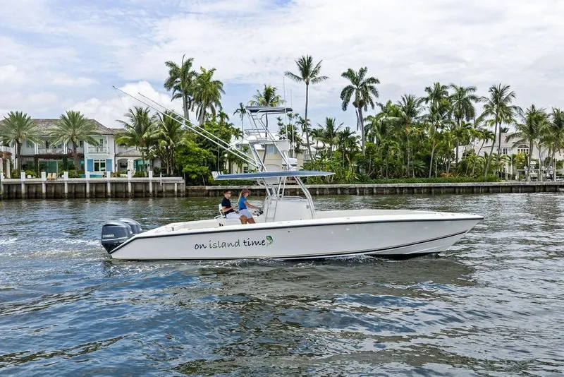 Slide: The Image of 1997 Venture 34 Center Console boat cruising near palm-lined waterfront homes. - 14
