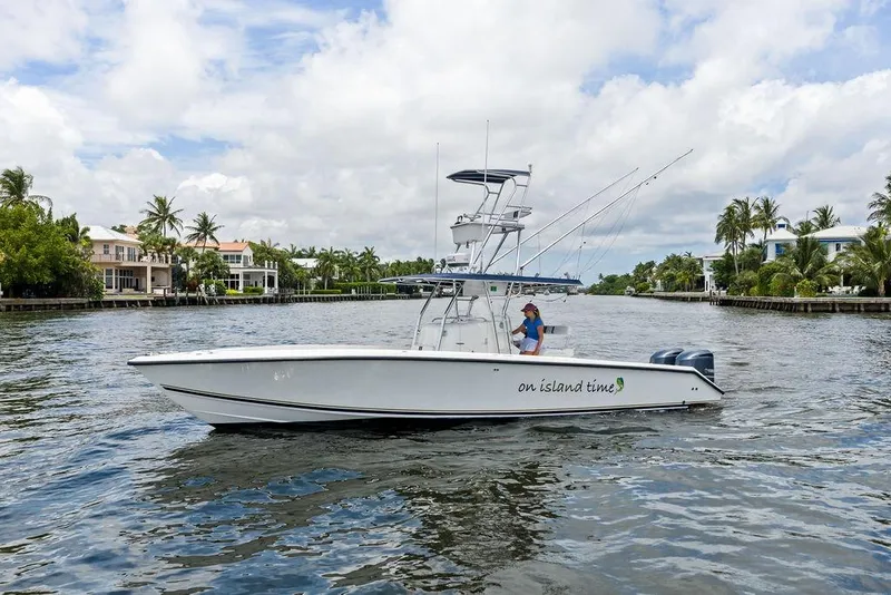Slide: The Image of 1997 Venture 34 Center Console boat cruising on a scenic waterway with palm trees. - 15