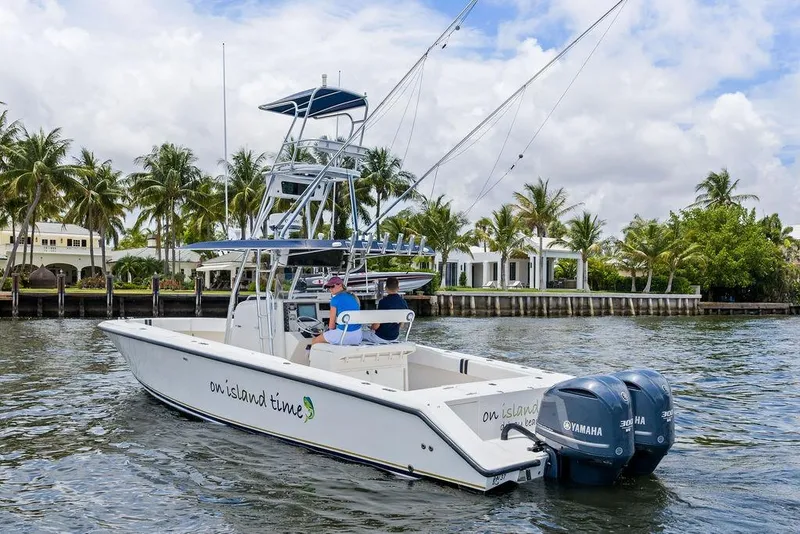 Slide: The Image of 1997 Venture 34 Center Console boat cruising near palm-lined waterfront homes. - 16