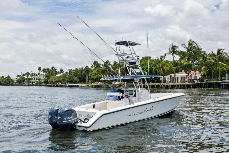Slide: The Image of 1997 Venture 34 Center Console boat cruising on a scenic waterway with palm trees. - 17