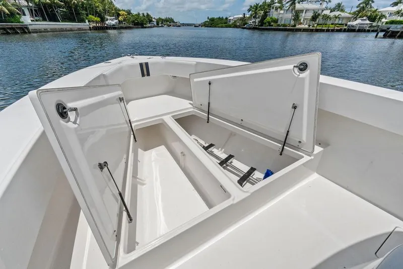 Slide: The Image of 1997 Venture 34 Center Console boat with open storage compartments on a calm waterway. - 22